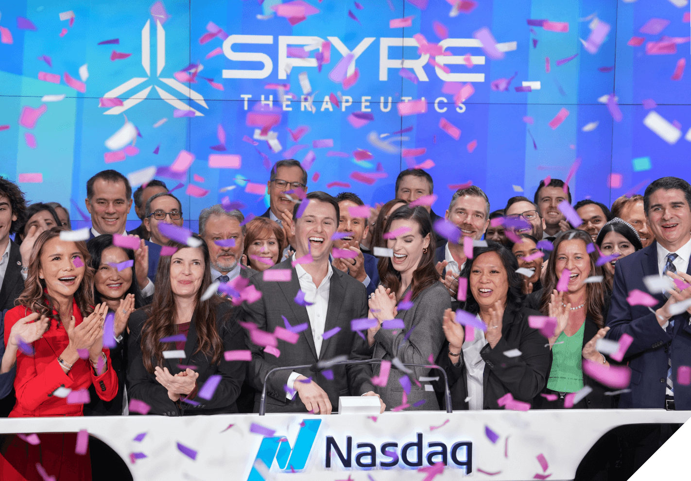 Group picture with employees celebrating with confetti for the Nasdaq bell ringing ceremony.