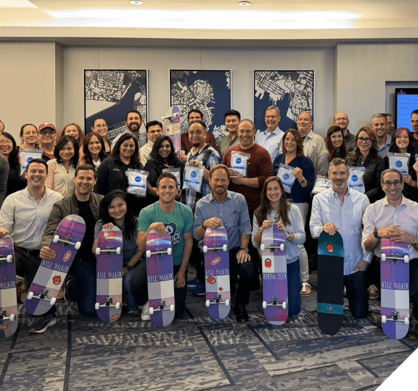 A group of employees holding skateboards from their Skate Like a Girl event.