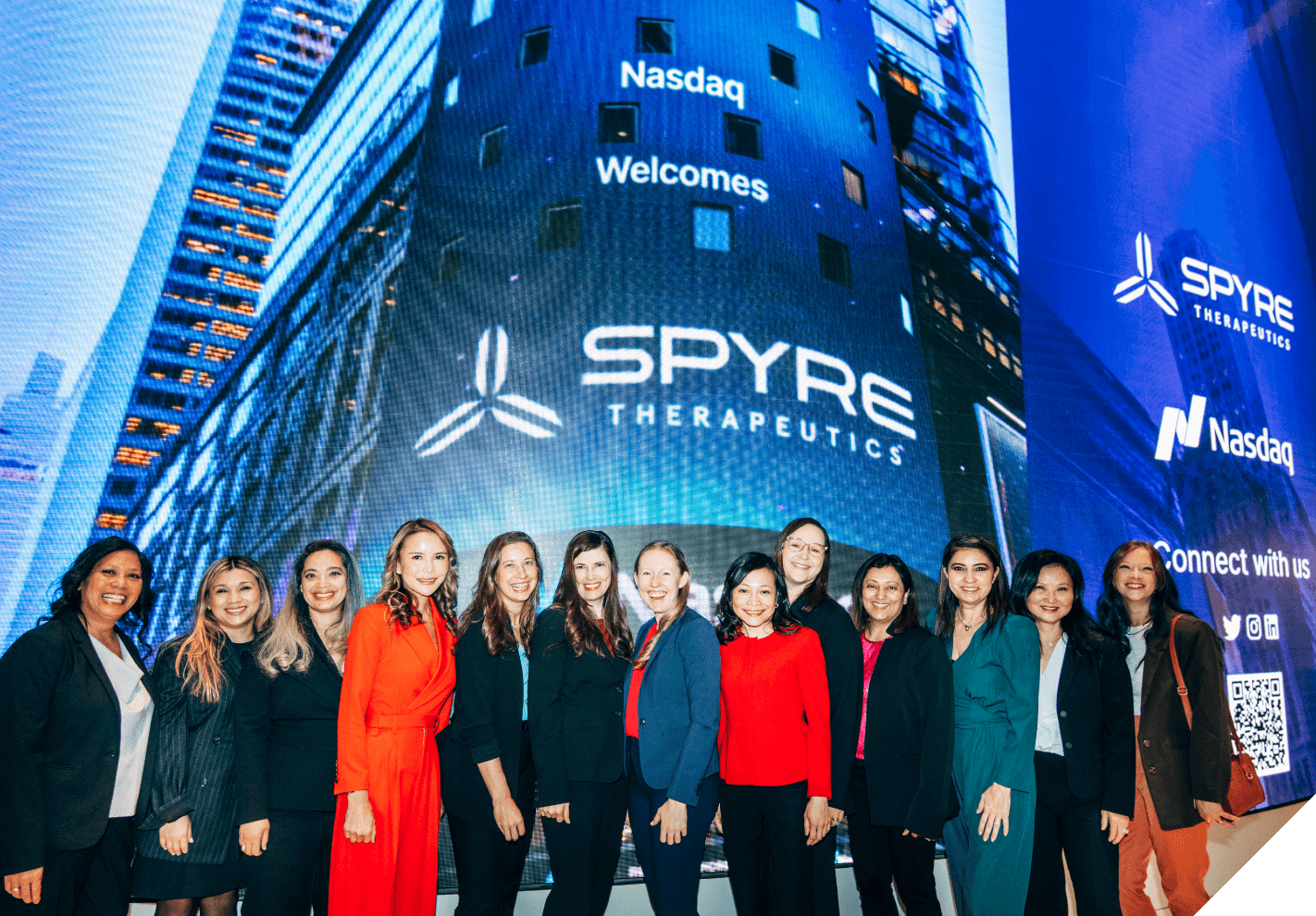 The women on the Spyre team standing in front of the Nasdaq billboard.