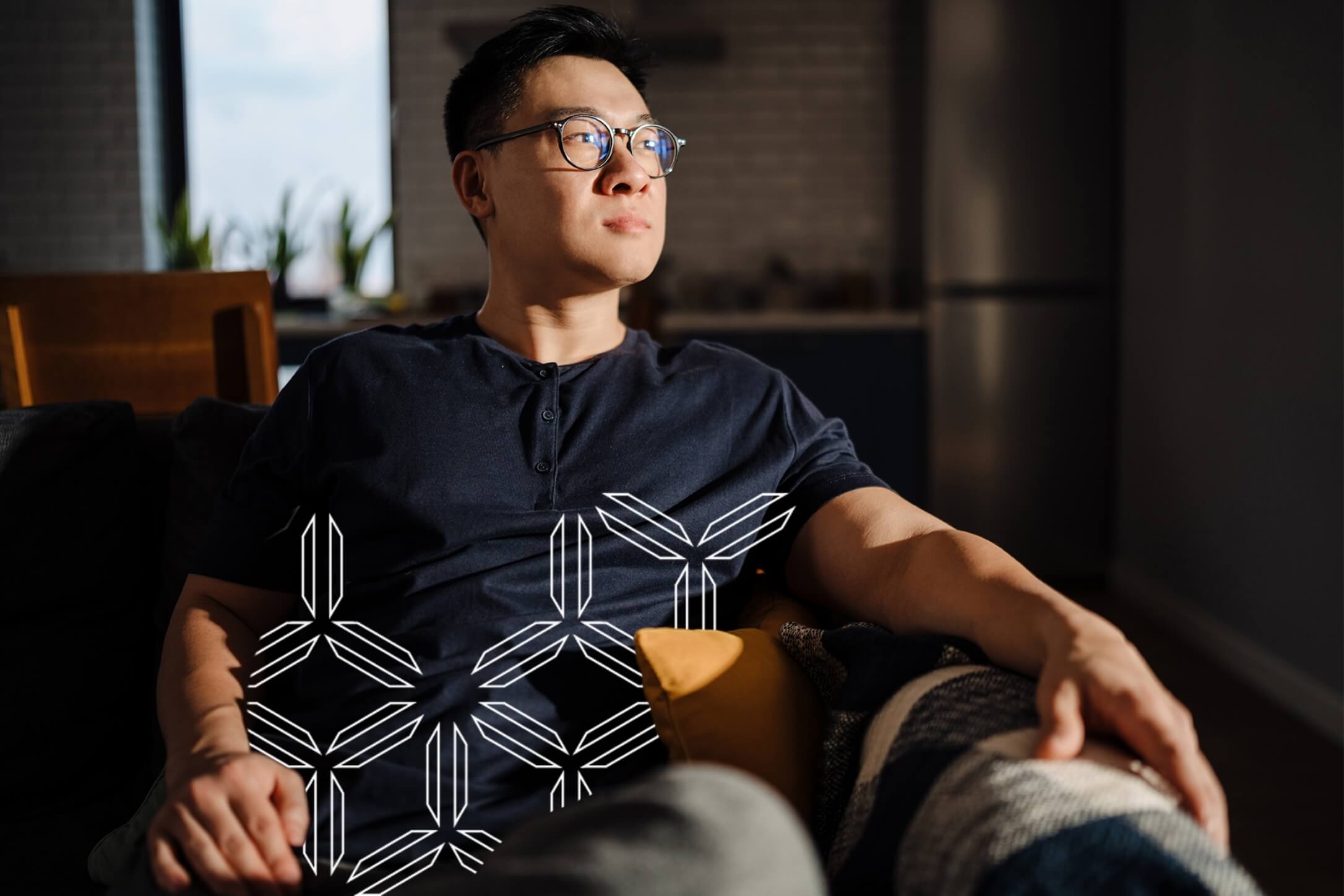 Man with glasses sitting on couch looks to the right